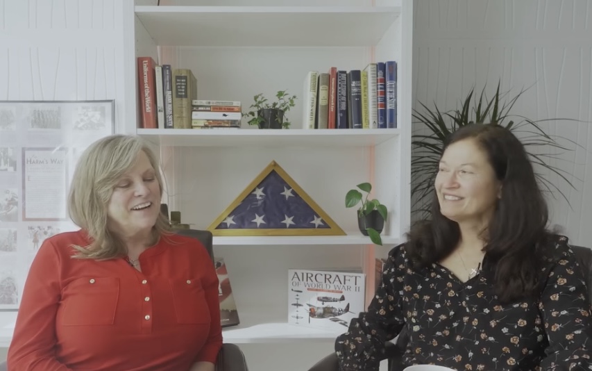 Carlene Hall Productions and Darlene McMartin recording Still Serving Iowa Veterans in a studio with books, plants and a folded American flag display behind them